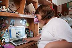 Una adolescente con sobrepeso trabaja frente a su ordenador